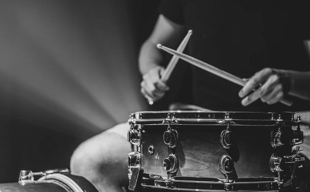 Ein Mann spielt mit Stöcken auf einer Trommel, ein Schlagzeuger spielt ein Percussion-Instrument, kopiert Raum. - Foto, Bild