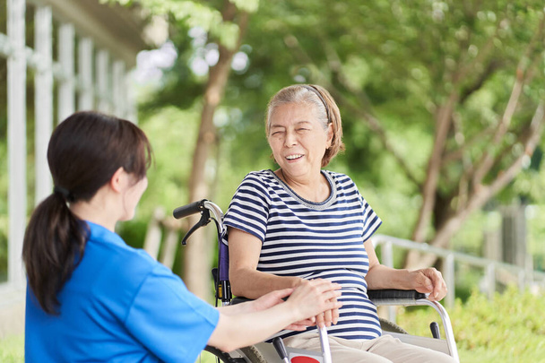 Jazda na wózku inwalidzkim osób starszych i opiekunów kobiet - Zdjęcie, obraz