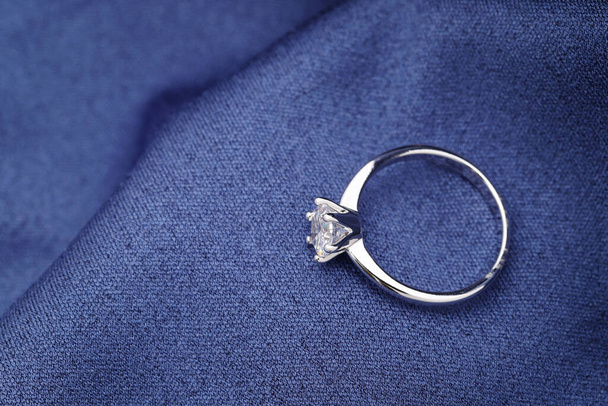 青い柔らかい布の上にエレガントなダイヤモンドリングの閉鎖 - 写真・画像