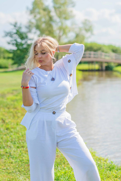 Nice blonde hair woman in cotton suit at golf field. Concept of women's style, fashionable collection - Fotografie, Obrázek