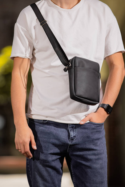 Cropped unrecognizable man holding his new messenger bag - 写真・画像