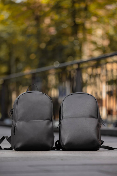 Two black leather backpacks in city - Zdjęcie, obraz