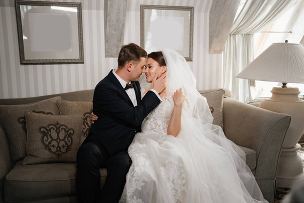 cheerful and happy bride and groom on the couch. a fun wedding.  - Photo, image