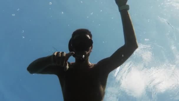 Een jongeman die in zee zwemt. Onderwaterzicht - Video