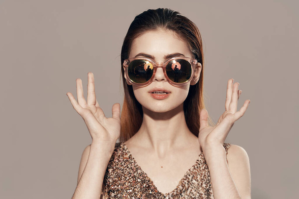 atraktivní žena nosí sluneční brýle zlaté šaty dekorace model studio - Fotografie, Obrázek