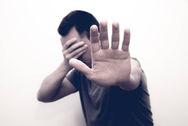 A man raising a hand to prohibit or cover her face to show resistance - Фото, изображение