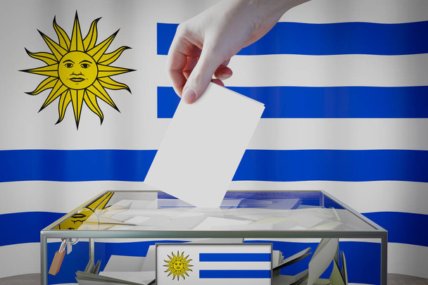 Urugway-Fahne, Hand wirft Wahlkarte in eine Schachtel - Abstimmung, Wahlkonzept - 3D-Illustration - Foto, Bild