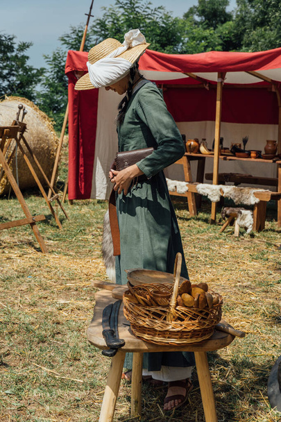 ARDUD, ROMANIA - Jul 24, 2021: A vertical shot of a woman dressed in medieval dress in sunny weather at a festival in Romania - Foto, immagini