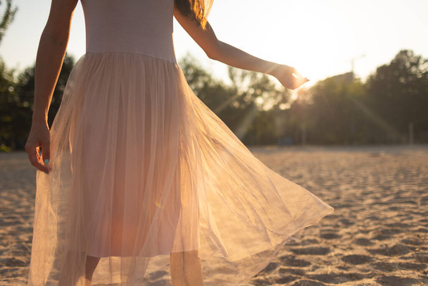 chica posando en un vestido transparente al atardecer. paseos por la playa por la noche - Foto, imagen