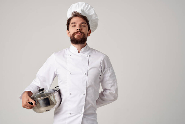 ένας άντρας με στολή σεφ με μια κατσαρόλα στα χέρια του εστιατόριο υπηρεσία μαγειρικής - Φωτογραφία, εικόνα