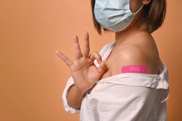 Kobieta ze szczepionym ramieniem. Szczepienia i szczepienia. - Zdjęcie, obraz