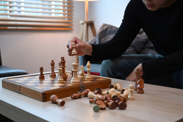 Young man sitting on couch and playing chess. - Foto, Bild