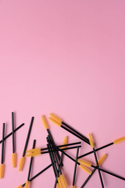 Cepillo negro desechable para pestañas y cejas sobre fondo rosa pastel. - Foto, imagen
