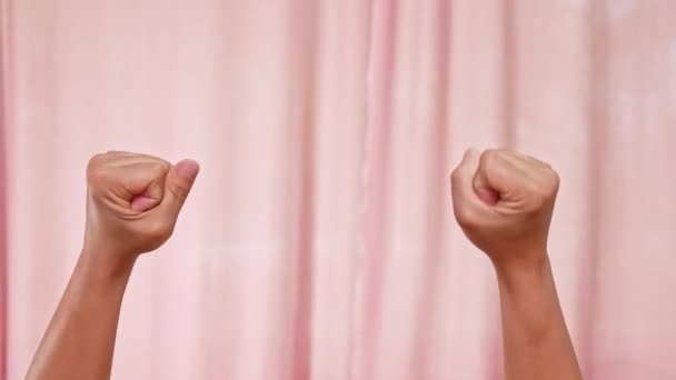 Руки поднятые в знак протеста изолированы на розовом фоне. Женщина руководит символом власти, кулаки подняты в знак протеста. концепция социальной справедливости и мирного протеста. - Кадры, видео