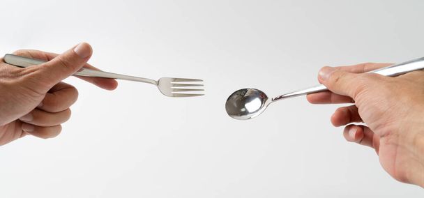hand holding silver fork and spoon on white background - Фото, зображення