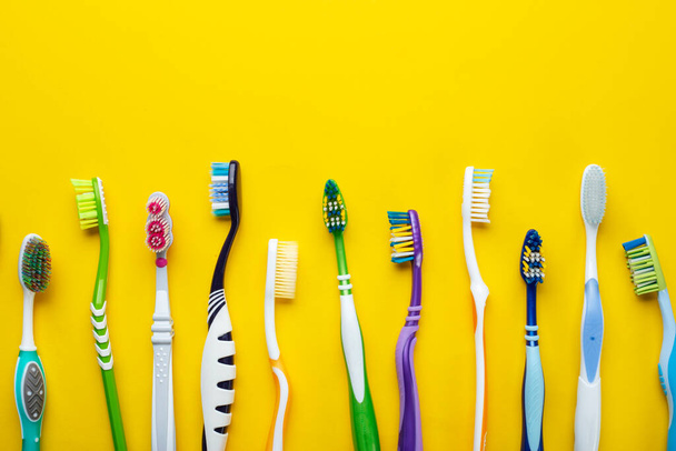 Toothbrushes on yellow background. Hygiene of the oral cavity. Top view. - Photo, image