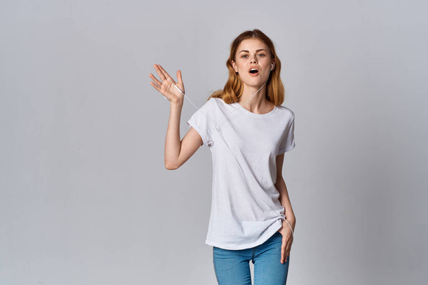 Nainen valkoinen t-paita muoti kuuntelee musiikkia eristetty tausta malli - Valokuva, kuva