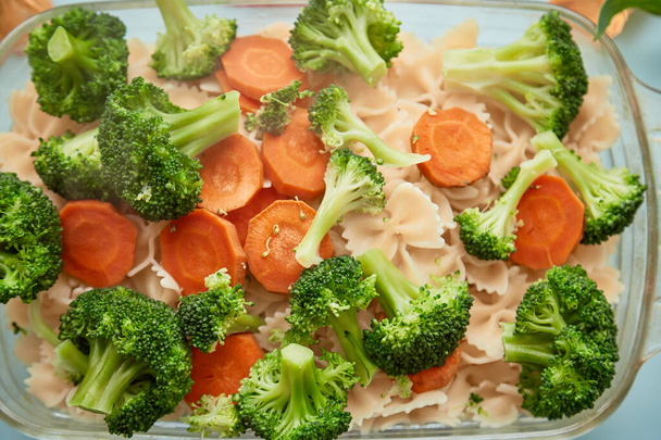 Gezond eten, mediterrane keuken, pasta met groenten: wortelen en broccoli. Bovenaanzicht, kopieer ruimte. Hoge kwaliteit foto - Foto, afbeelding