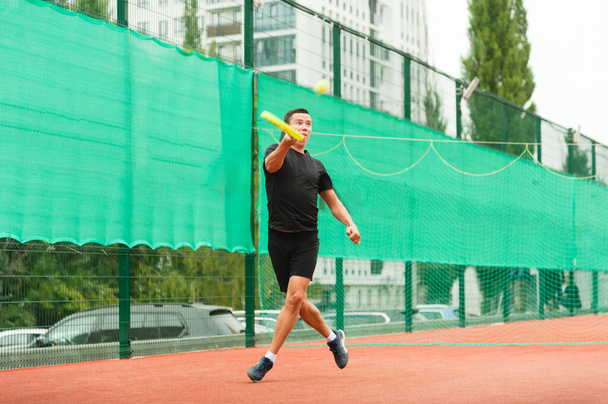 A male tennis player is elegantly hitting a tennis ball. A tennis player who looks like a dancer. - Фото, зображення
