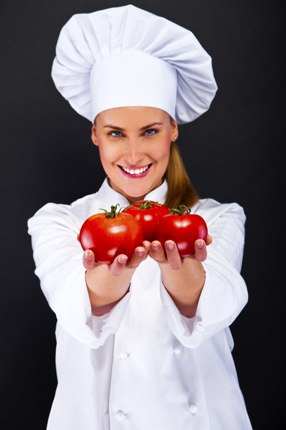 Portrait of young woman chef with tomatos  - Φωτογραφία, εικόνα