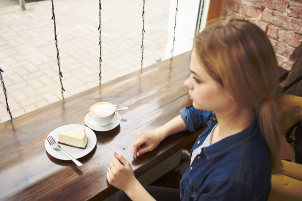 mujer bonita sentada en una mesa en un café snack desayuno - Foto, Imagen