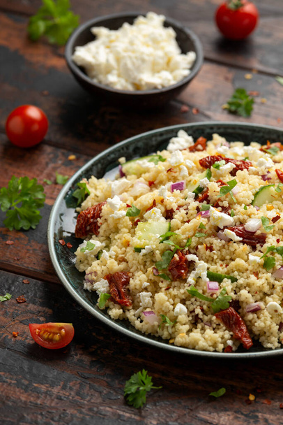 Couscous salad with sun dried tomatoes, cucumber, red onion and feta cheese. healthy food. - Photo, Image