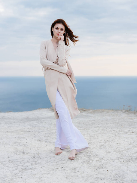 beautiful woman in coat sand summer elegant style - Фото, изображение