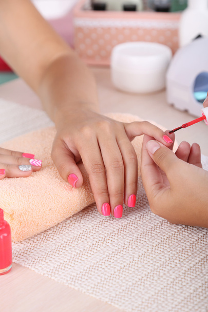 Young woman is getting manicure - Foto, Imagen