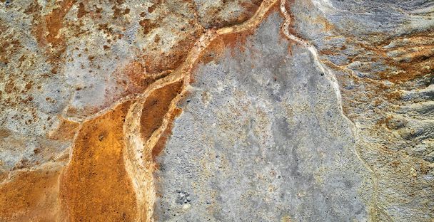 Dried rusty river bed over wasteland grey background, contamination texture, drone view directly above - Photo, Image