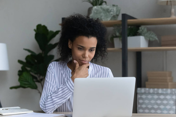 Pensive black business lady read analytic report from laptop screen - Fotografie, Obrázek
