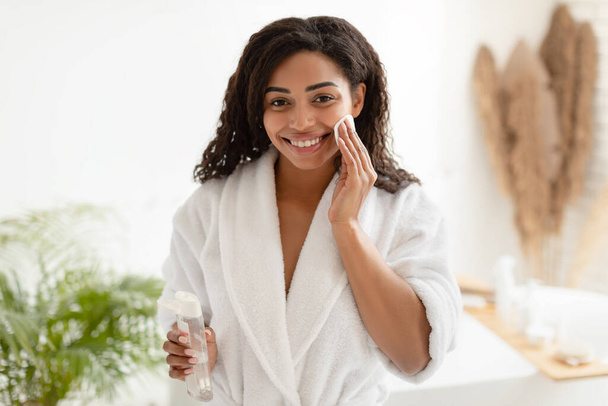 African Lady Using Cotton Pad Holding Micellar Water In Bathroom - Photo, Image