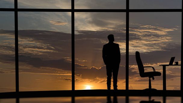 Ο επιχειρηματίας στέκεται κοντά στα παράθυρα στο κέντρο του γραφείου - Φωτογραφία, εικόνα