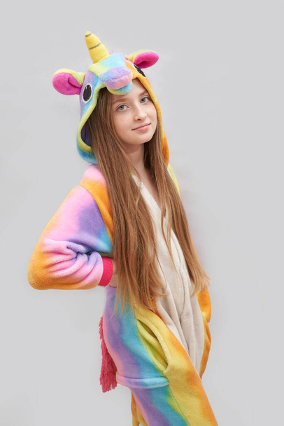 Young pretty girl in unicorn bairthday pajama. Colorful sleep jumpsuit. - Foto, immagini