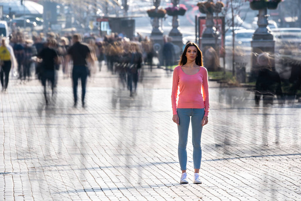 Die Frau steht inmitten einer überfüllten Straße - Foto, Bild