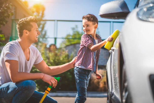 Le père et son petit fils nettoient la voiture - Photo, image