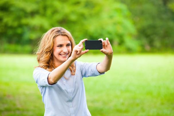 Nice woman taking pictures with smartphone - Foto, immagini