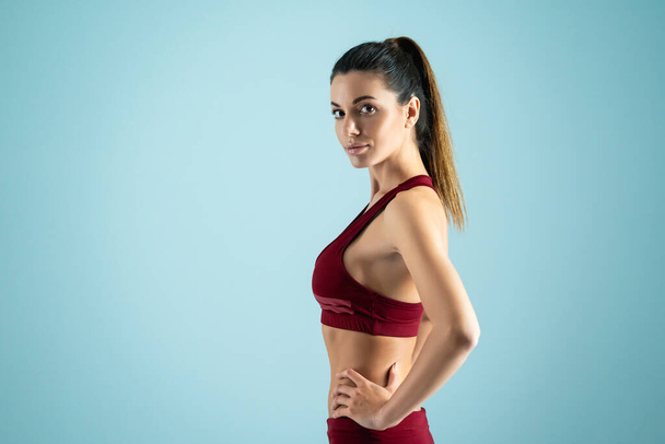Das schöne Fitness-Model posiert im Lichtstudio vor der Kamera - Foto, Bild