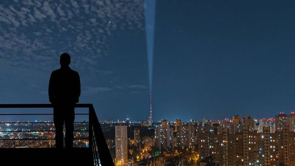 L'homme debout sur le balcon sur le fond de la ville de nuit - Photo, image