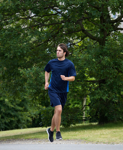 Nuori urheilullinen mies juoksee ulkona
 - Valokuva, kuva