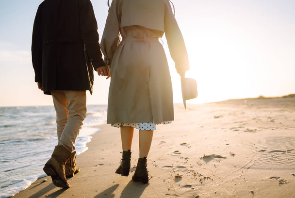 Young couple having fun walking and hugging on beach during autumn sunny day. Relaxation, youth, love,  lifestyle solitude with nature. - Foto, Imagen