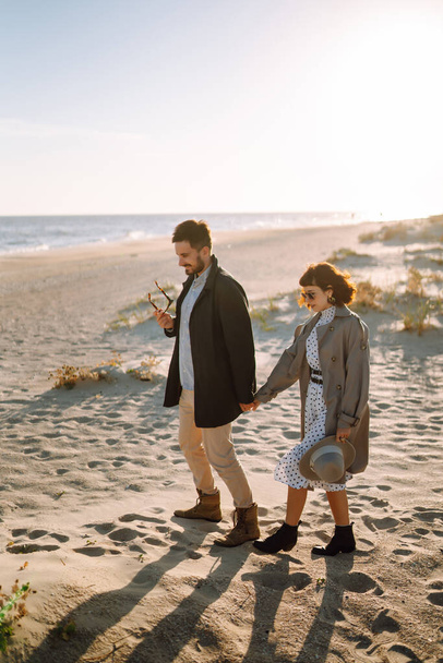 Young couple having fun walking and hugging on beach during autumn sunny day. Relaxation, youth, love,  lifestyle solitude with nature. - Foto, immagini