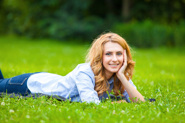 Smiling blonde woman in green grass showing love - Fotó, kép