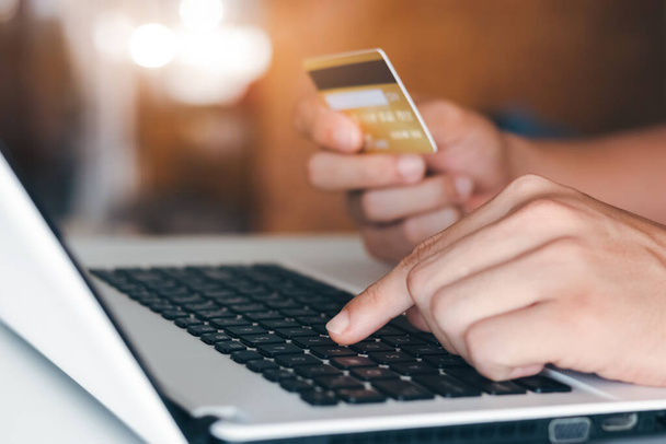 ビジネスマンは自宅で注文をしながらオンラインショッピングのためのラップトップを使用してクレジットカードを保持手。ビジネスライフスタイルテクノロジーeコマースデジタルバンキングオンライン決済の概念. - 写真・画像
