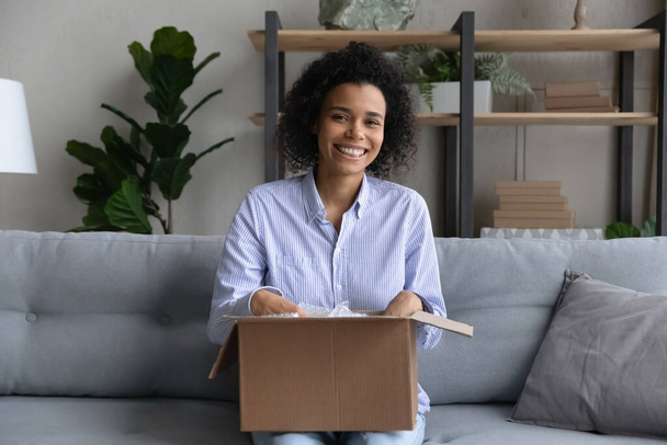 Excited young biracial woman realty buyer pack belongings for relocation - Zdjęcie, obraz