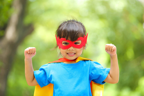 Earth day concept. A cute little girl joy and childhood have confidence action with dressed and wearing mask and cape of superhero kid.Children dream and imagination. - Fotoğraf, Görsel
