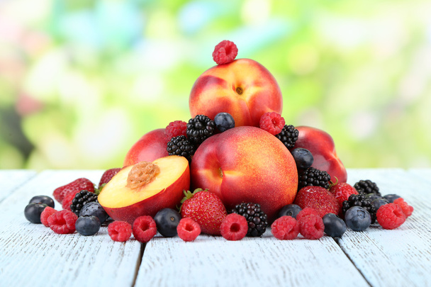 Peaches with berries on table - Φωτογραφία, εικόνα