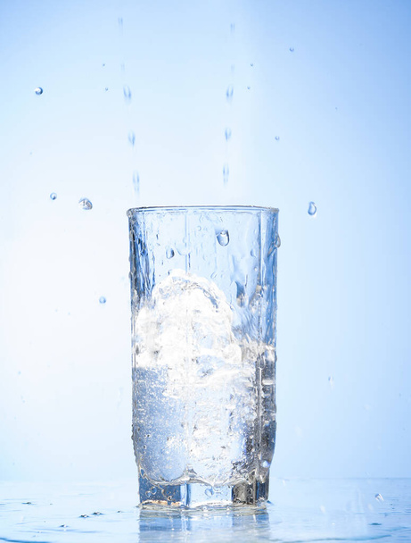 water splash in glass  isolated on blue background.  - Foto, Imagem