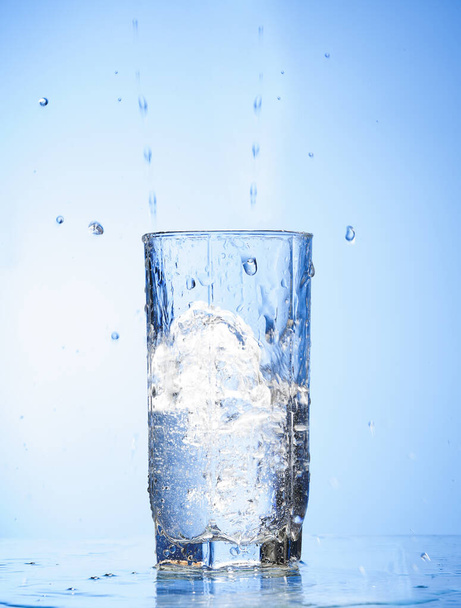 water splash in glass  isolated on blue background.  - Foto, Bild