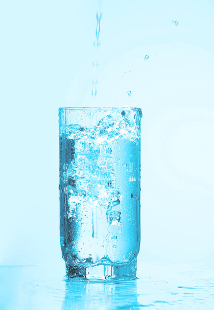  nalewanie wody do szklanki odizolowanej  - Zdjęcie, obraz