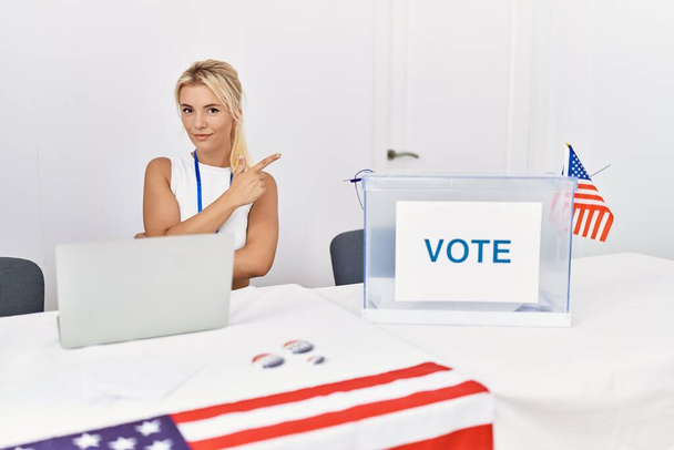 Молода жінка в американській політичній кампанії вказує пальцем на бік, показуючи рекламу, серйозне і спокійне обличчя  - Фото, зображення